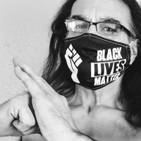 Michael Mendoza, wearing a Black Lives Matter face mask, holds a kempo bow.